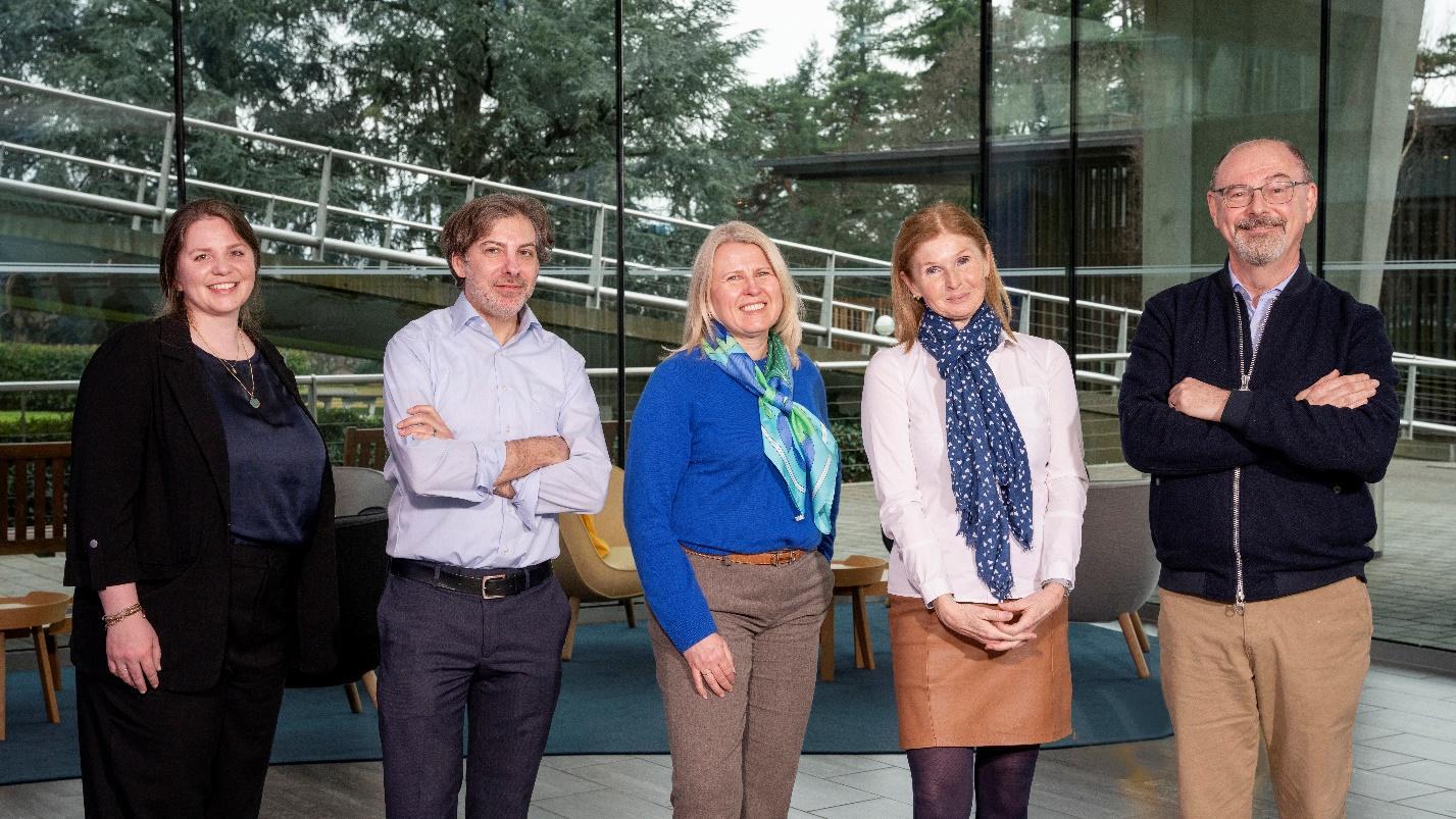 A group of people standing in a roomDescription automatically generated